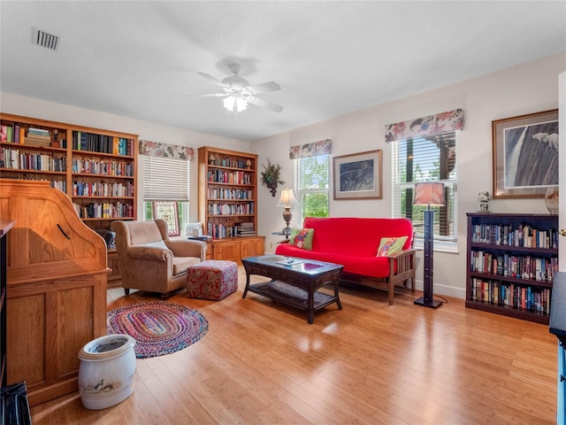 living room featuring a wealth of natural light, ceiling fan, and light wood-type flooring