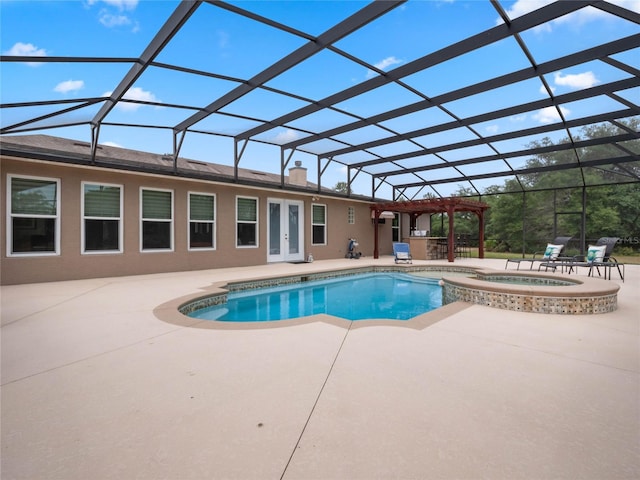 view of swimming pool featuring a patio area, glass enclosure, and an in ground hot tub