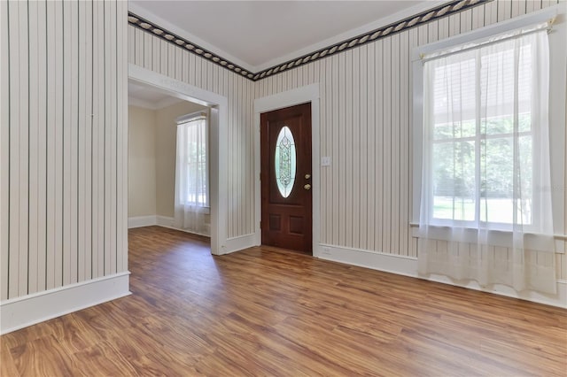 foyer entrance with hardwood / wood-style floors and crown molding