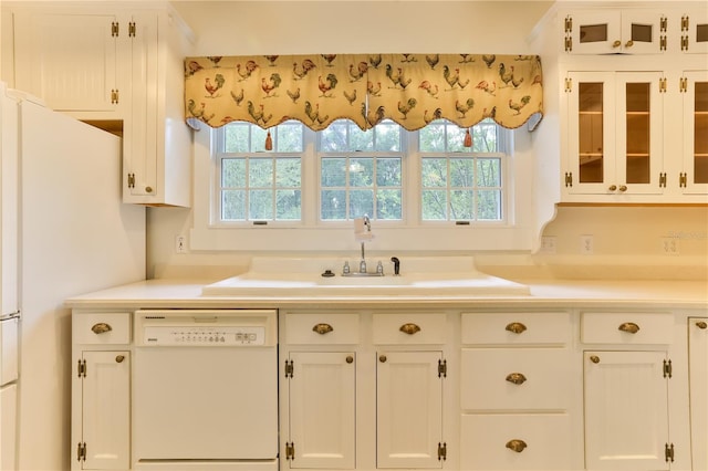 kitchen featuring white cabinetry, plenty of natural light, white dishwasher, and sink