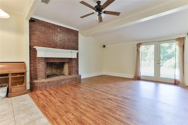 unfurnished living room featuring lofted ceiling with beams, ceiling fan, wood-type flooring, and a brick fireplace