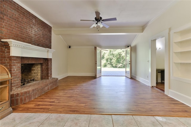 unfurnished living room featuring ceiling fan, built in features, light hardwood / wood-style floors, and a brick fireplace