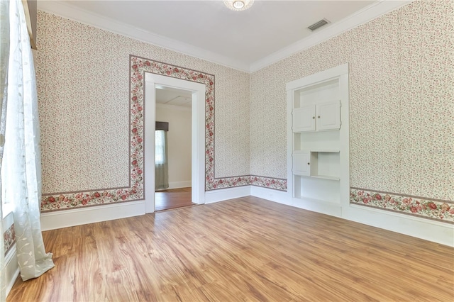 spare room with hardwood / wood-style floors and crown molding