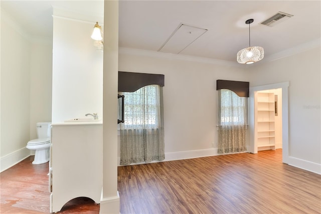 bathroom with hardwood / wood-style flooring, a wealth of natural light, ornamental molding, and sink