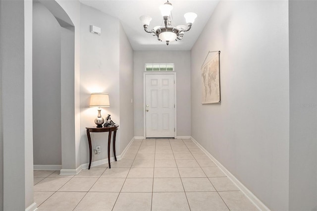 doorway featuring an inviting chandelier and light tile floors