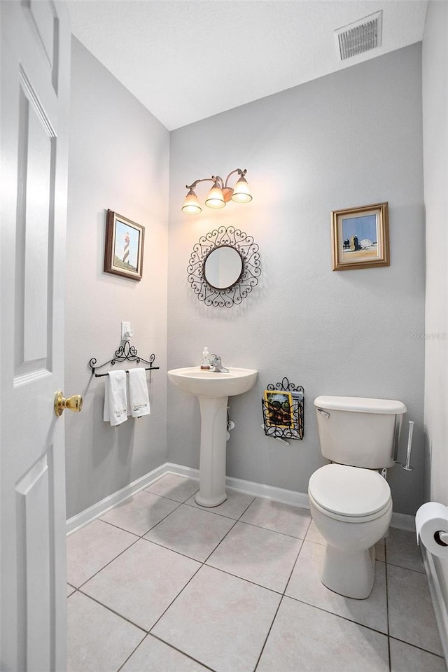 bathroom featuring tile flooring and toilet