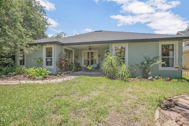 view of front of house featuring ceiling fan, a front lawn, and a patio area