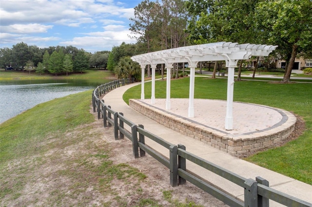 view of home's community with a pergola, a water view, and a yard