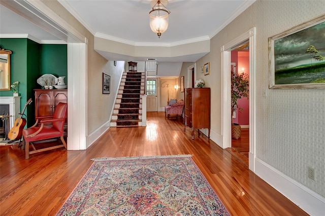 corridor with hardwood / wood-style floors and crown molding