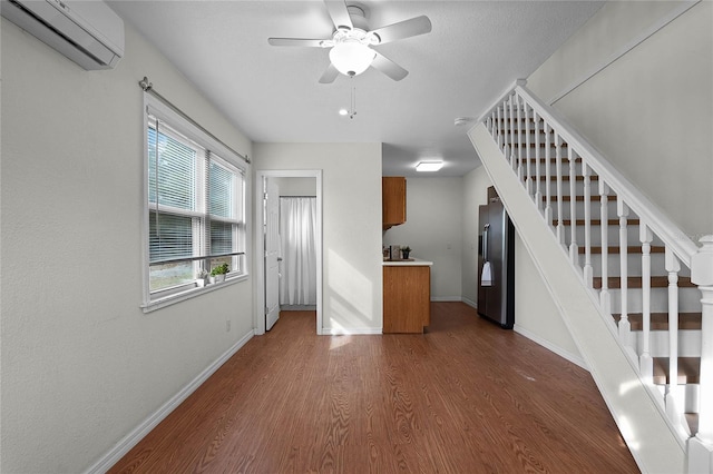 interior space featuring a wall unit AC, ceiling fan, and dark wood-type flooring