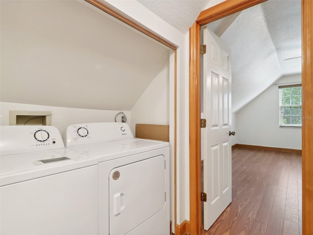 laundry area with washer and clothes dryer, a textured ceiling, and hardwood / wood-style flooring