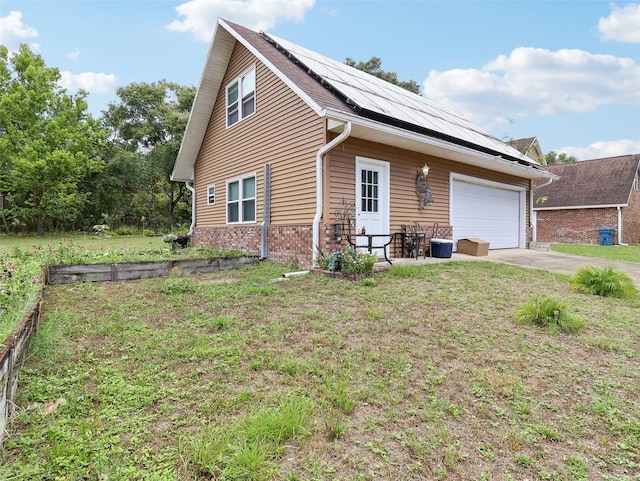 view of front of home with solar panels, a garage, and a front lawn