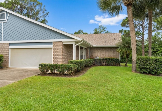 single story home featuring a garage and a front lawn