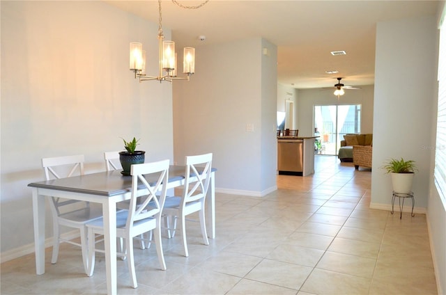 dining area featuring light tile flooring and ceiling fan with notable chandelier