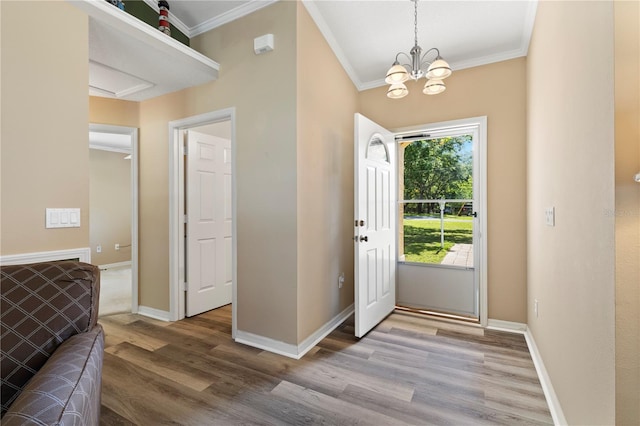 entrance foyer with hardwood / wood-style floors, a chandelier, and ornamental molding