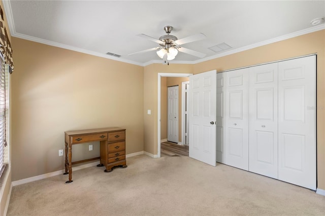 bedroom with ceiling fan, ornamental molding, a closet, and light colored carpet