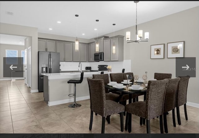 tiled dining space featuring sink and an inviting chandelier