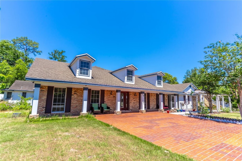 cape cod-style house with covered porch and a front yard