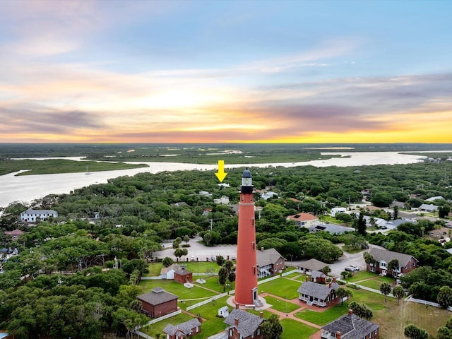 aerial view at dusk featuring a water view