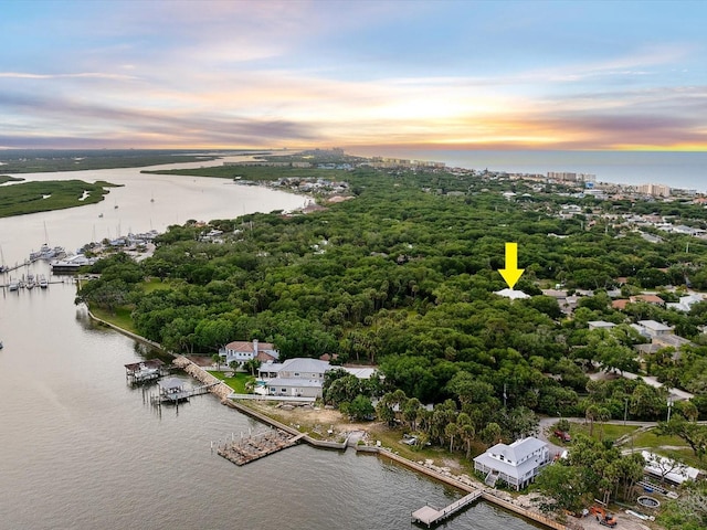 aerial view at dusk featuring a water view