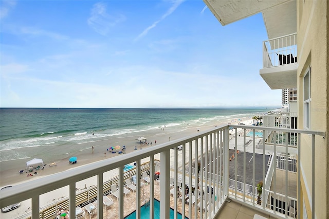 balcony with a water view and a beach view