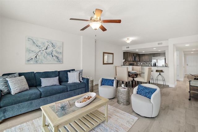 living room with light wood-type flooring and ceiling fan