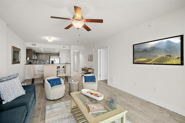 living room with light hardwood / wood-style floors and ceiling fan