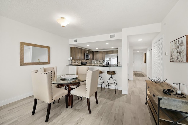 dining space with light hardwood / wood-style floors