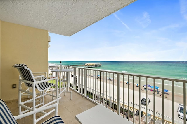 balcony featuring a water view and a beach view