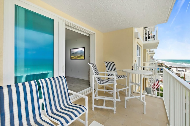 balcony featuring a beach view and a water view