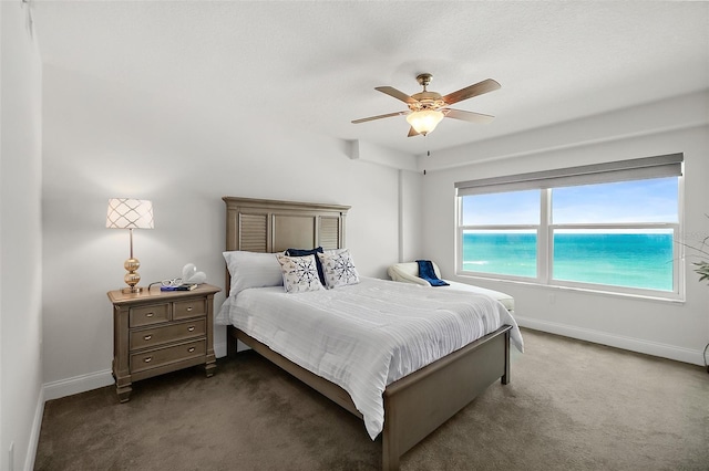 carpeted bedroom with a water view and ceiling fan