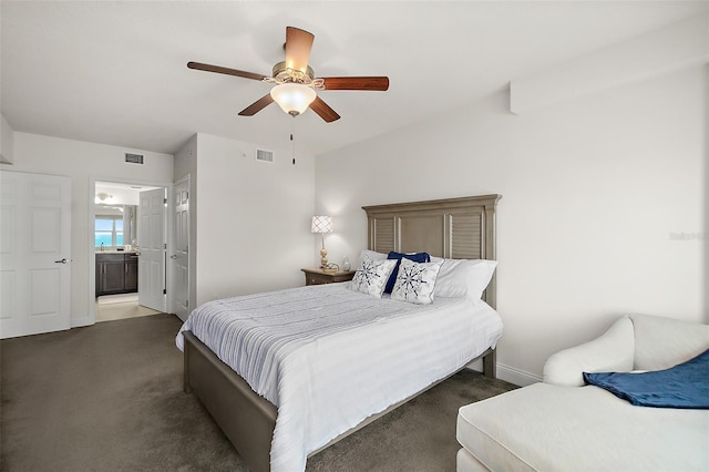 bedroom featuring dark carpet, ensuite bath, and ceiling fan