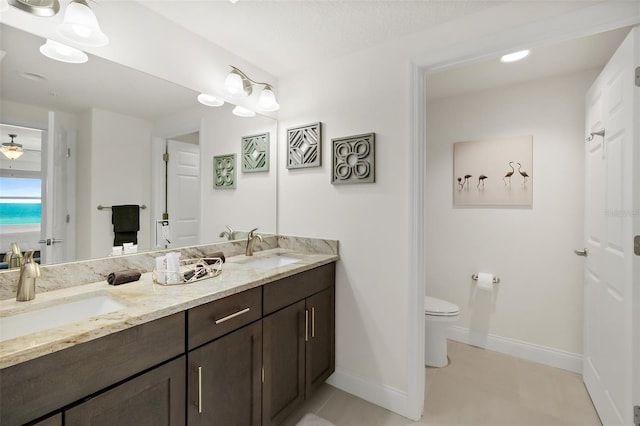 bathroom with tile patterned flooring, vanity, and toilet