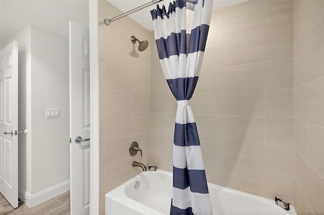 bathroom with hardwood / wood-style flooring and shower / tub combo with curtain