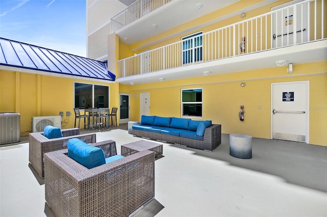 view of patio with outdoor lounge area, a balcony, and central AC