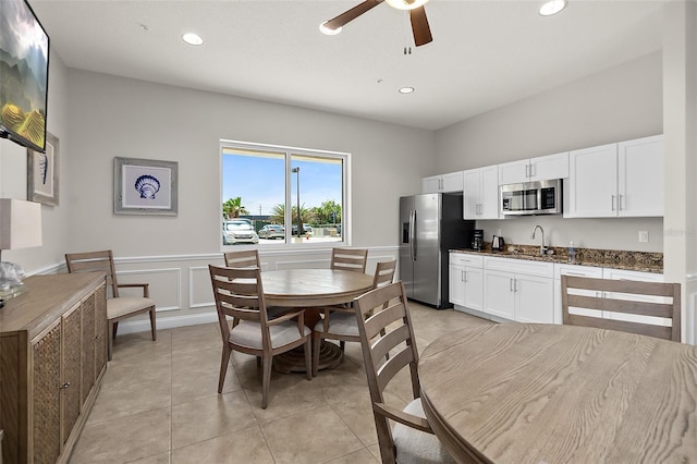 dining space featuring ceiling fan, sink, and light tile patterned flooring