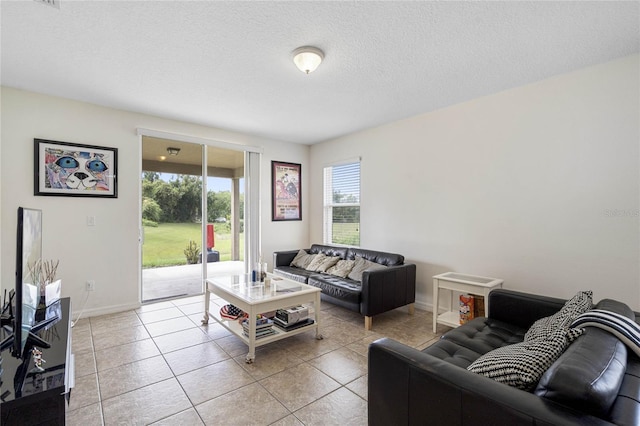 tiled living room featuring a textured ceiling