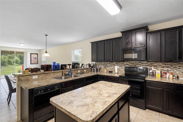 kitchen featuring black appliances, a healthy amount of sunlight, kitchen peninsula, and a kitchen island