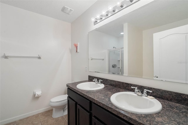 bathroom with a shower with shower door, double vanity, tile patterned flooring, a textured ceiling, and toilet