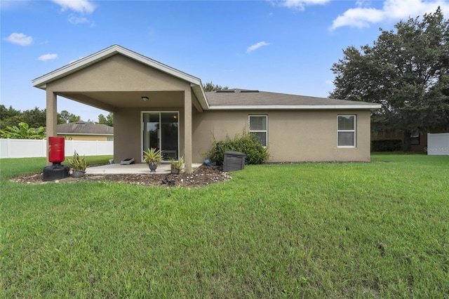 rear view of property featuring a patio and a lawn