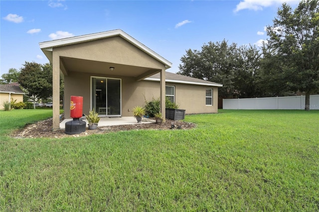 back of property with a patio and a lawn