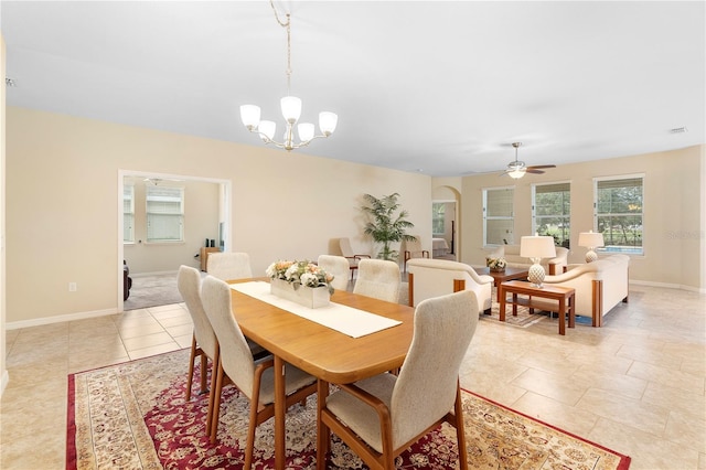 dining space with ceiling fan with notable chandelier