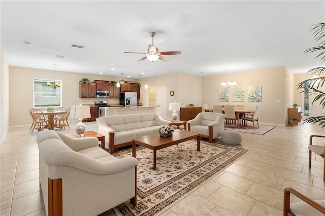 tiled living room with ceiling fan with notable chandelier