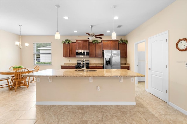 kitchen featuring a kitchen bar, appliances with stainless steel finishes, and a center island with sink