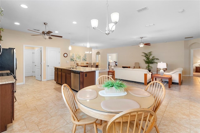 dining room featuring sink and ceiling fan with notable chandelier