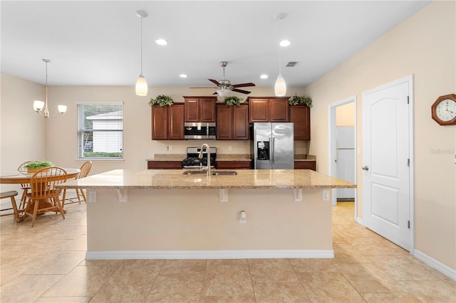 kitchen with a kitchen breakfast bar, stainless steel appliances, and a kitchen island with sink