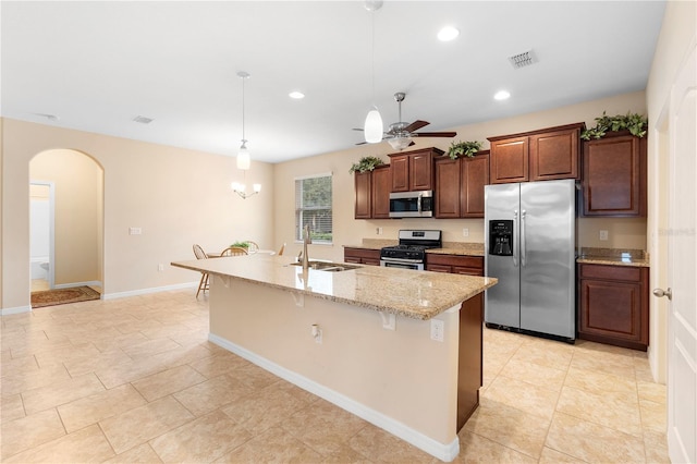 kitchen featuring hanging light fixtures, sink, a breakfast bar area, an island with sink, and stainless steel appliances