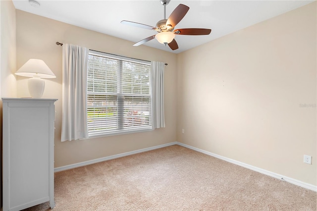 carpeted spare room featuring ceiling fan