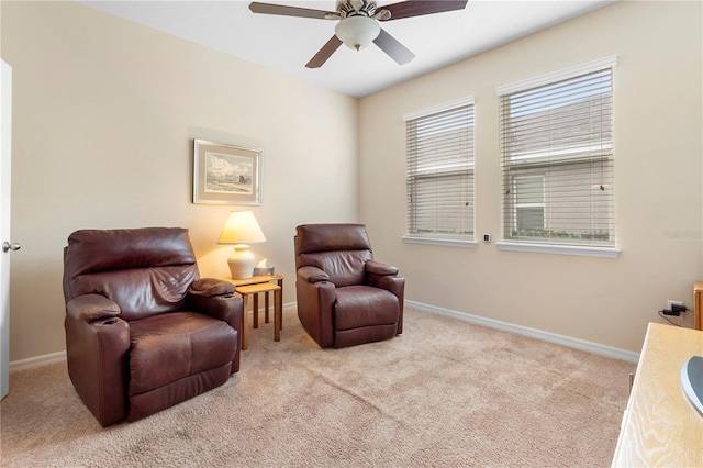 living area featuring light colored carpet and ceiling fan