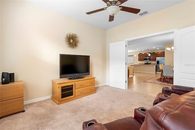 carpeted living room with ceiling fan with notable chandelier